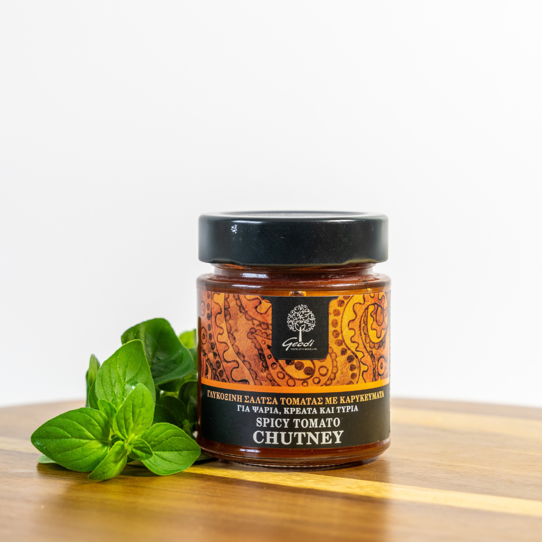 Jar of spicy tomato chutney with a label on a wooden surface