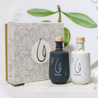 Two Staliá olive oil bottles with a decorative box on a light background