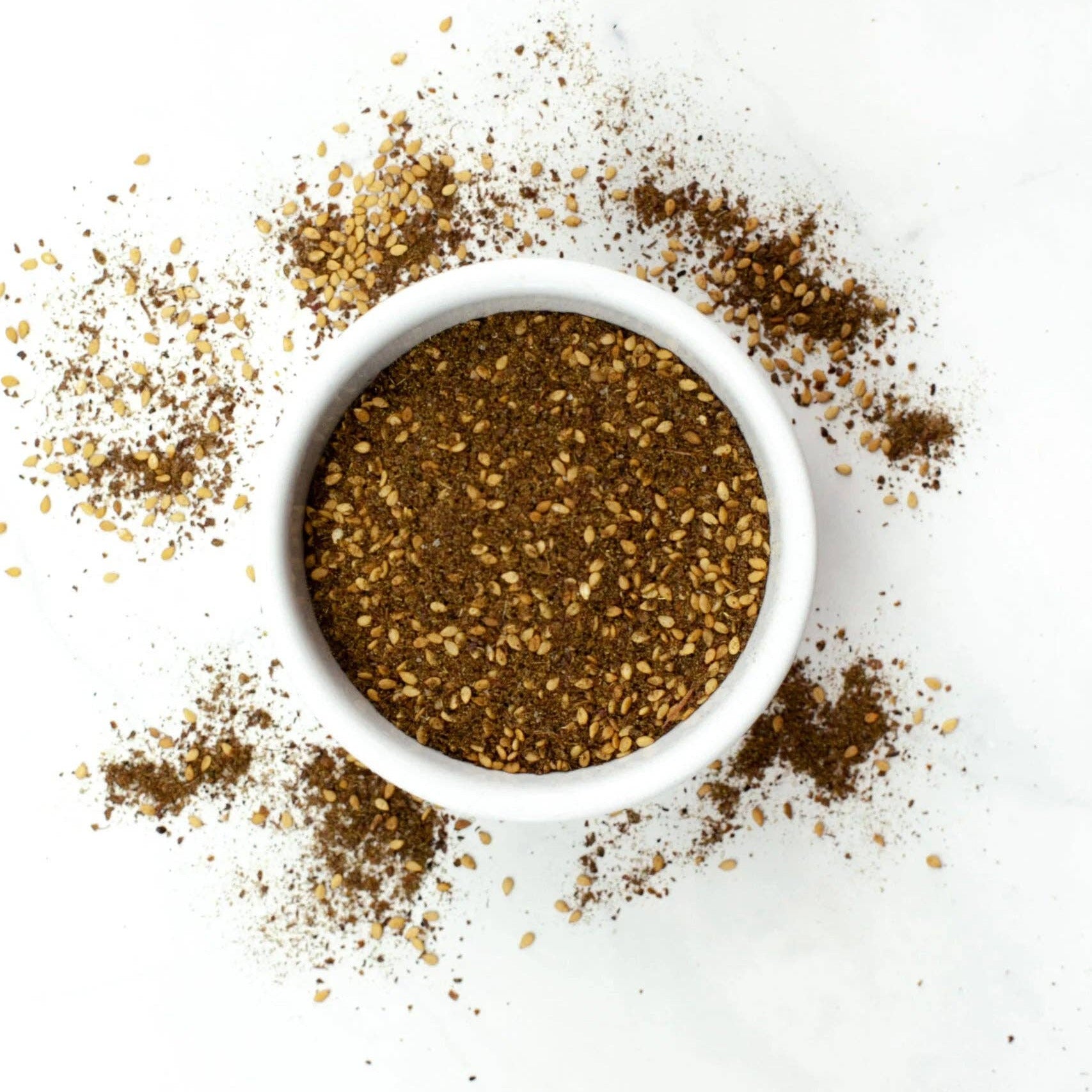 White bowl filled with ground pepper on a white background